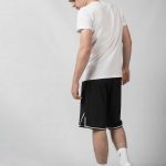 Young Guy walking wearing a white Baller Boys Basukettoboru Tee, black Big Ballin shorts and white Nike Sneakers